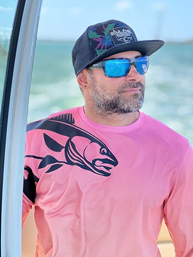Model wearing Soul Fuel Snap Back Ball Cap and Redfish Performance Long Sleeve UPF 50